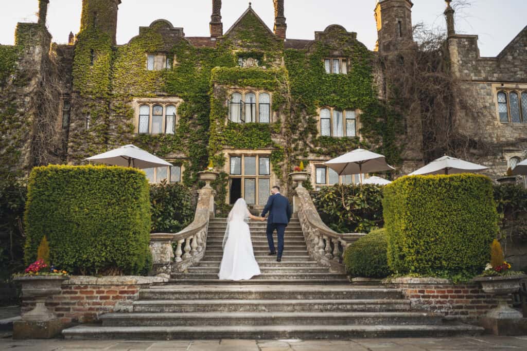 Bride and groom walking up stairs to Eastwell Manor