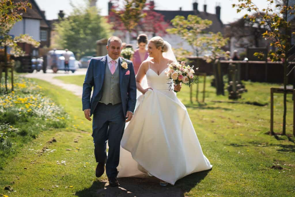 Father of the bride with his daughter walking to the church