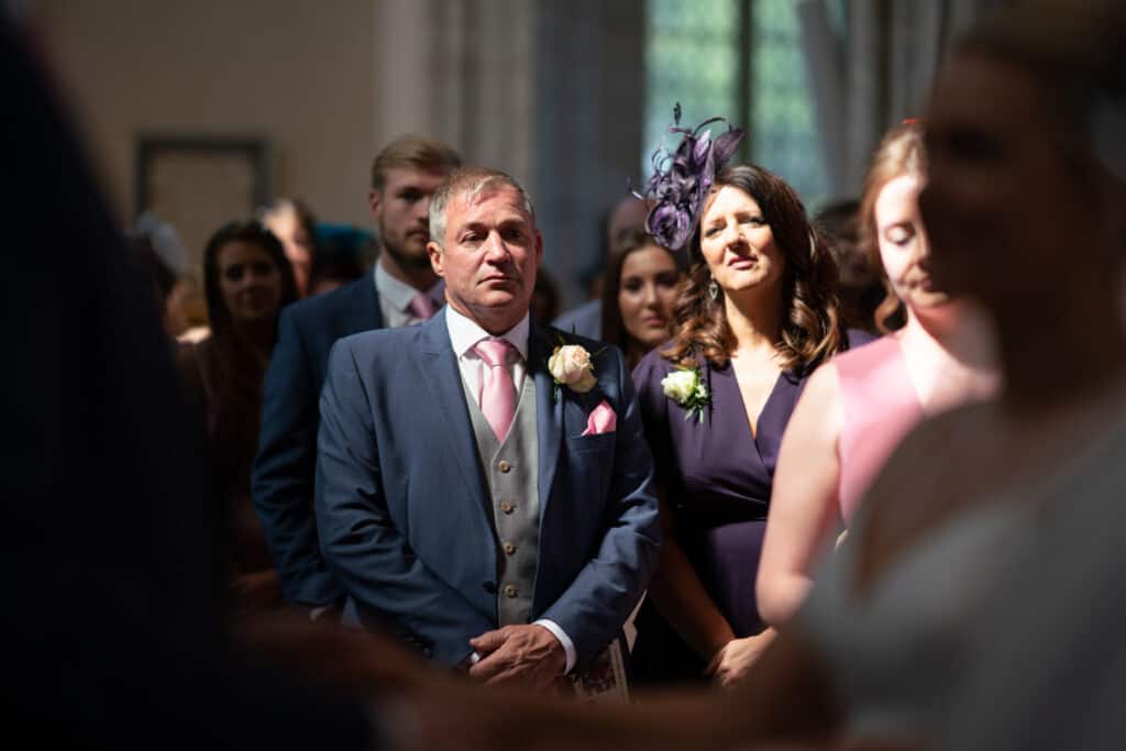 Father of the bride and guests at church ceremony