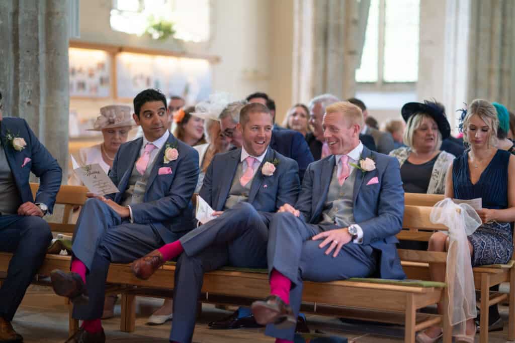 Groomsmen with pink socks in church