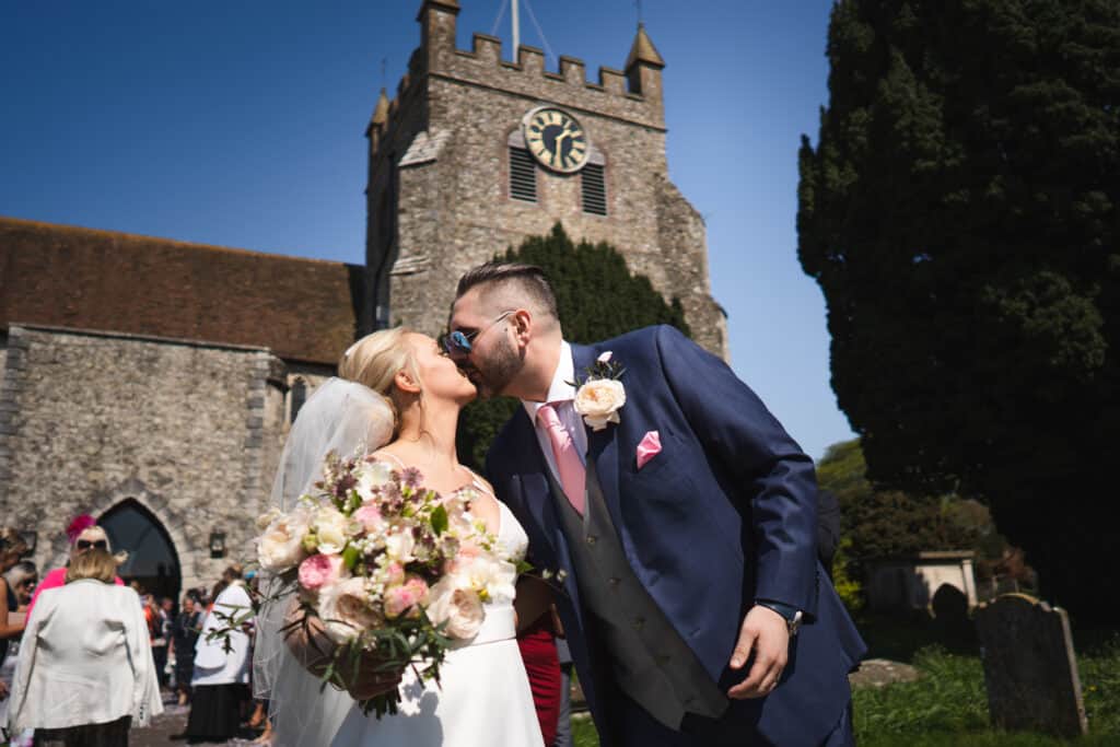 Bride and groom kissing in front of church