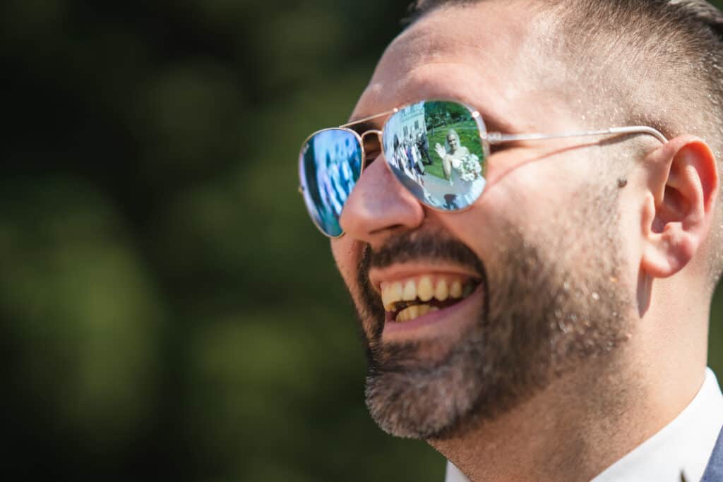 Wedding reflection in groom's sunglasses