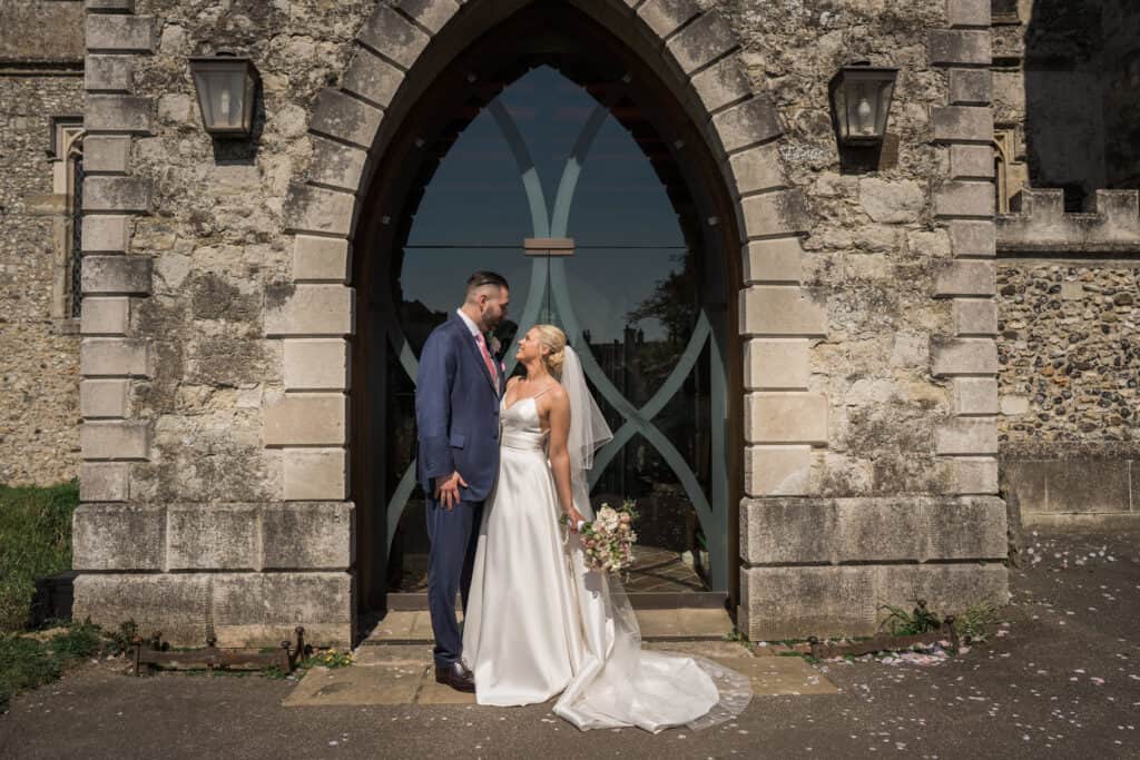 Bride in beautiful wedding dress with groom in front of the church