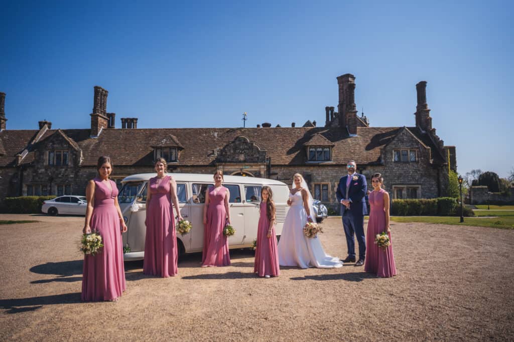 Bride, groom and bridesmaids with wedding VW campervan at Eastwell Manor wedding