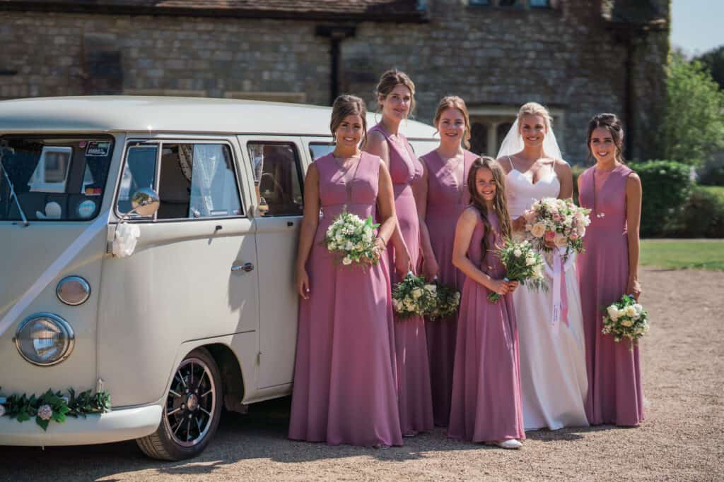 Bride and her bridesmaids in front of wedding VW campervan