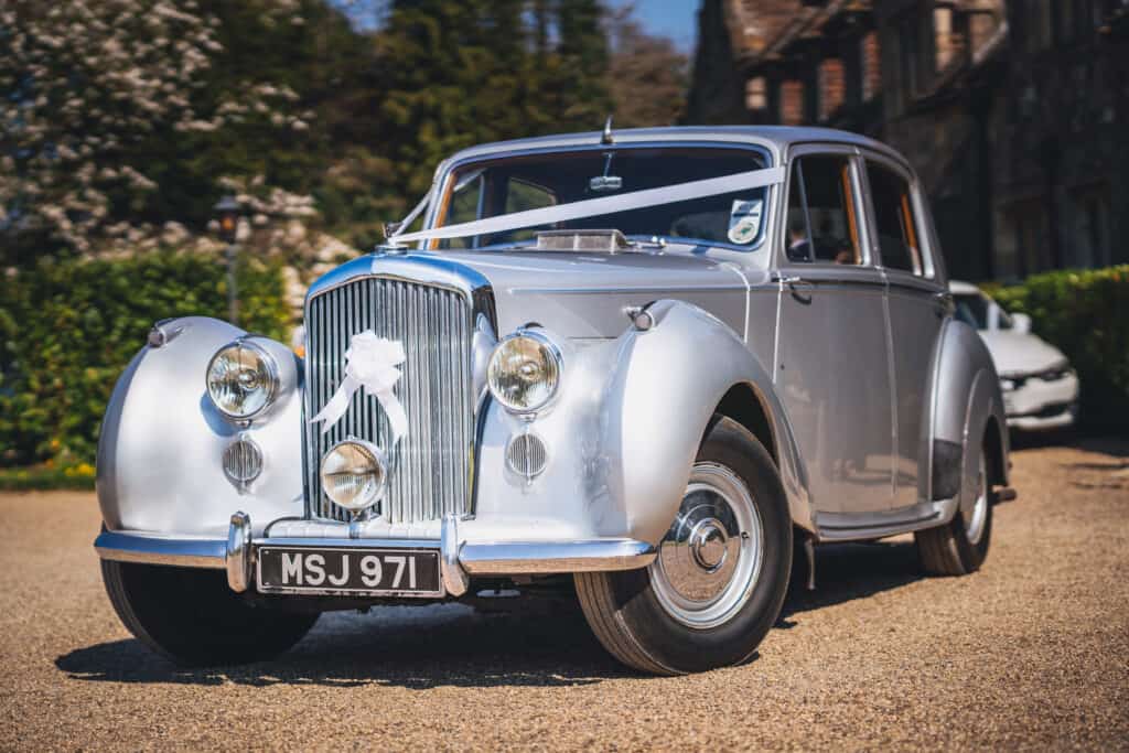 Silver Bentley wedding car at Eastwell Manor wedding