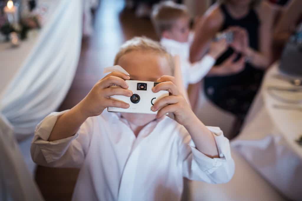 child at wedding taking photo