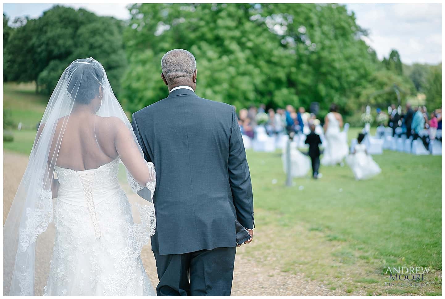 father and bride walking down the aisle outside